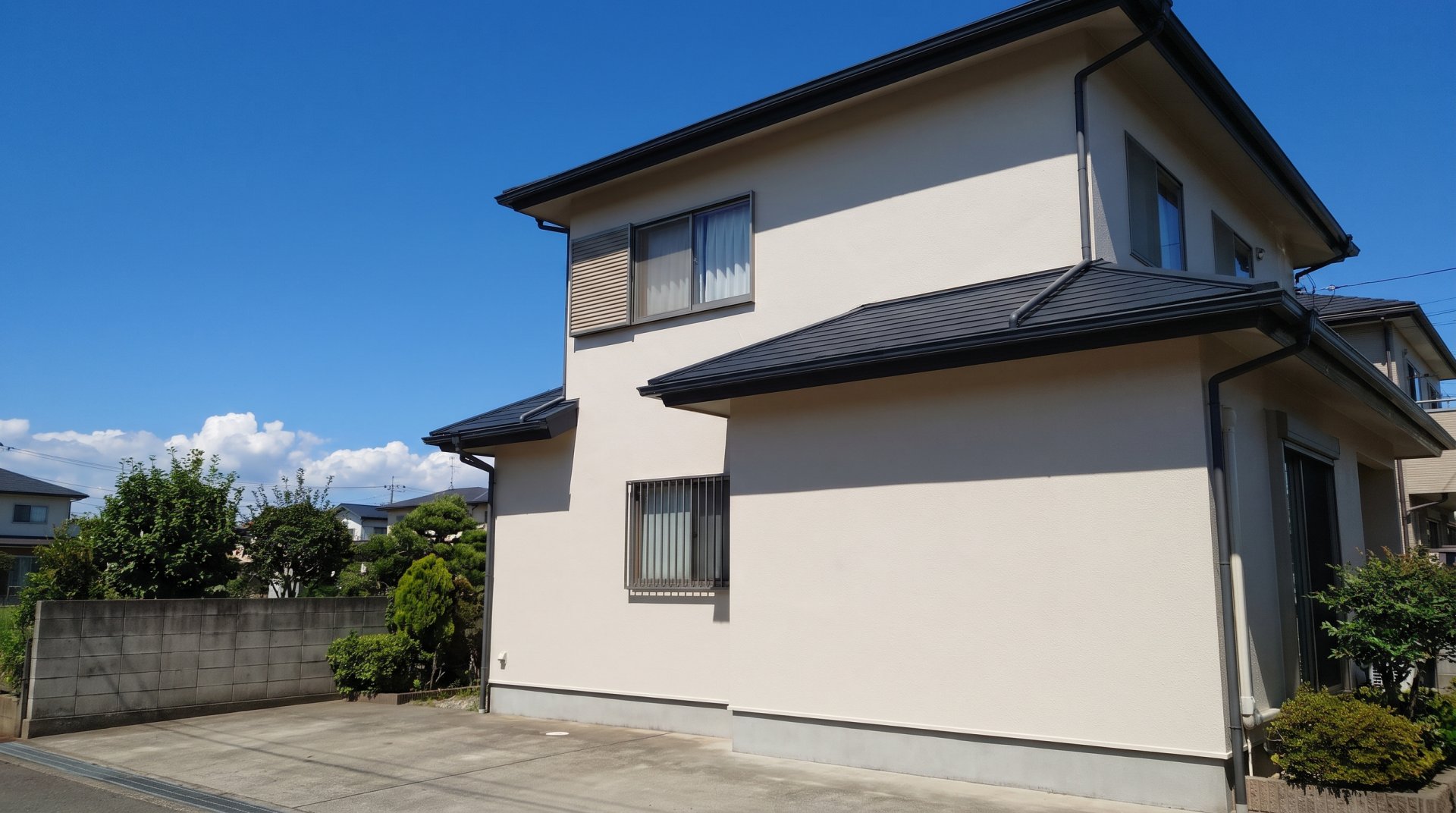 塗り替えたばかりの、明るい色のモルタル外壁の2階建ての家（見本の画像）